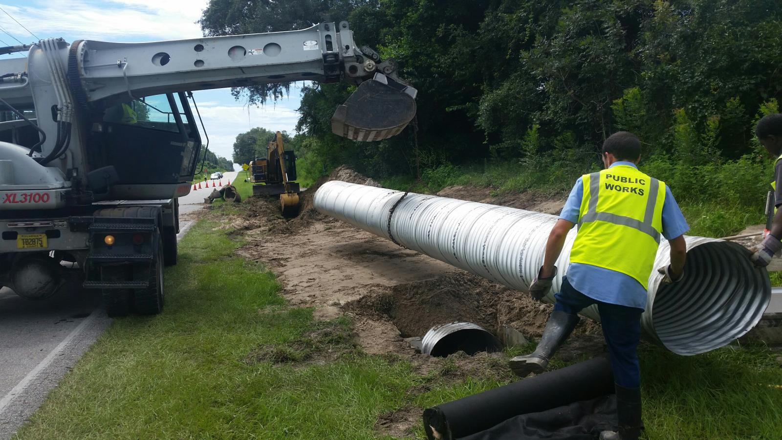 Public works installing new drainage pipe on the side of the road